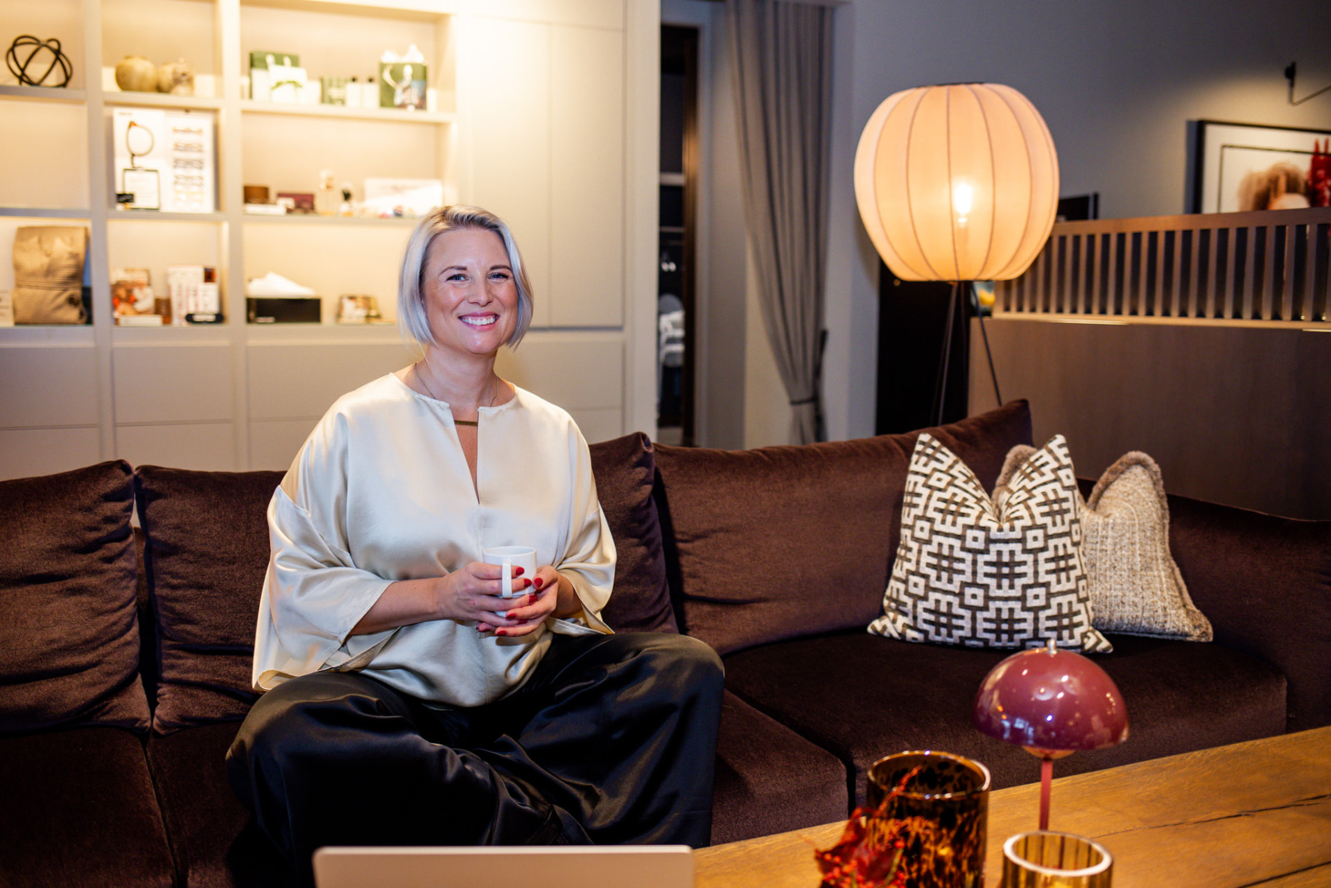 Amanda Randau sitter i en soffa med en kopp te
