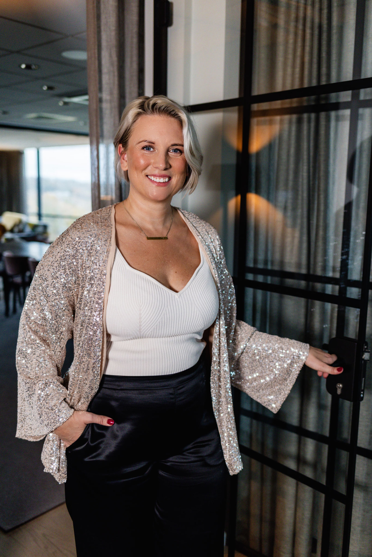 Amanda Randau i paljettkavaj vid en glasdörr